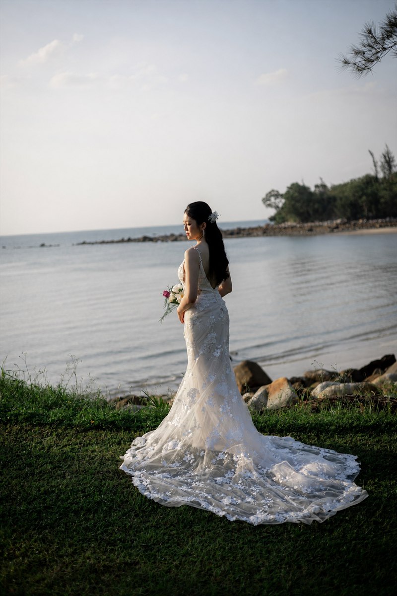 Caroline holding her bouquet beside the waterfront